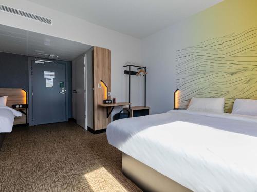 Cette chambre comprend un grand lit et un bureau. dans l'établissement B&B HOTEL Sélestat Centre-Alsace, à Sélestat