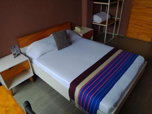 a small bedroom with a bed with a pillow on it at Hotel Momotus Tuxtla - Desayuno opcional in Tuxtla Gutiérrez