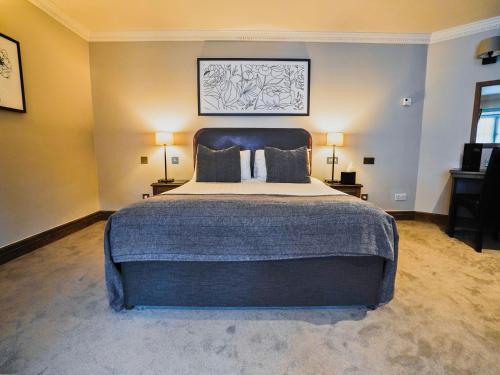 a bedroom with a large bed and two lamps at Villiers Hotel in Buckingham