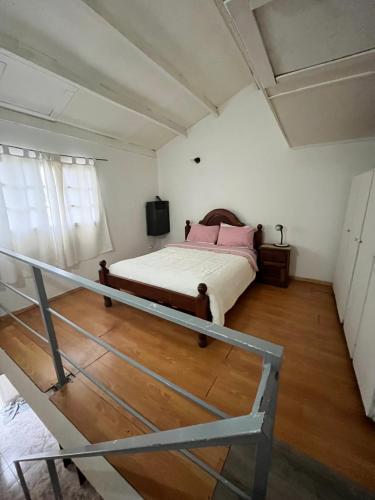 Un dormitorio con una cama con almohadas rosas. en Alquiler en el CENTRO Luz en Río Gallegos
