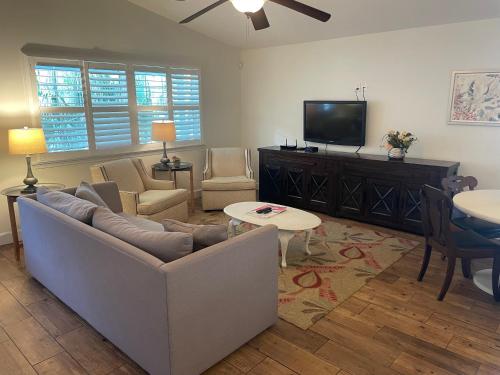a living room with a couch and a tv at Modern, Upscale, and New Blue Bungalow in the heart of Downtown St Augustine in St. Augustine