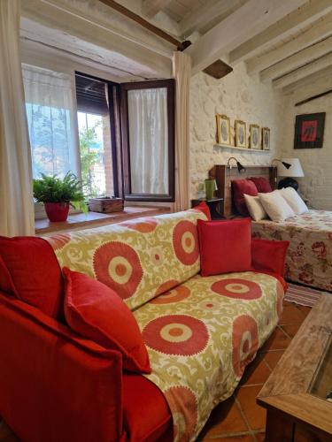 ein Wohnzimmer mit einem Sofa und einem Bett in der Unterkunft El Atalanto in Madrigal de la Vera