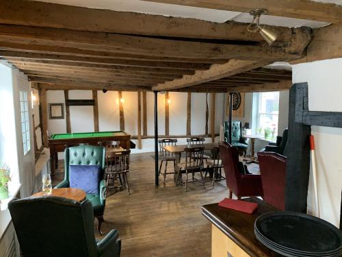a living room with tables and chairs and a pool table at The Rose and Crown in Elham