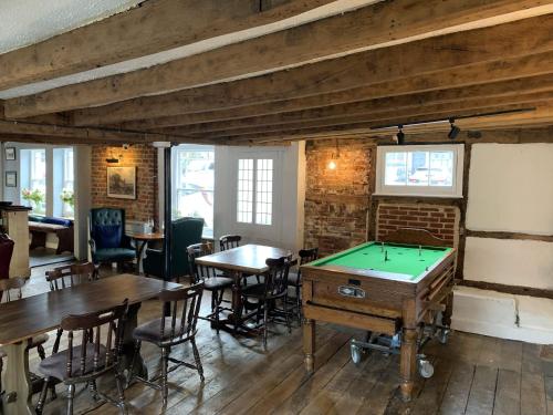 a room with tables and a pool table at The Rose and Crown in Elham
