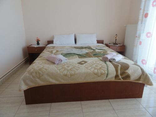 a bedroom with a large bed with two pillows at Pension Delfini in Asprovalta