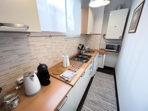 a kitchen with white cabinets and a wooden counter top at Da Irene in Bassano del Grappa