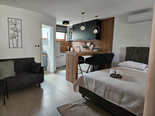 Apartments Frama Poreč - Funtana في فونتانا: غرفة نوم بسرير ومطبخ مع طاولة