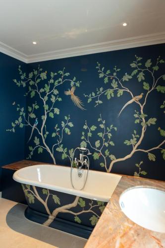 a bathroom with a bath tub and a bird mural at The City of London Club in London