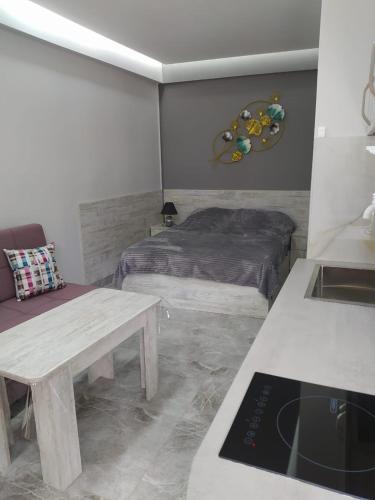 a bedroom with a bed and a table in it at Apart hotel Alex in Yerevan