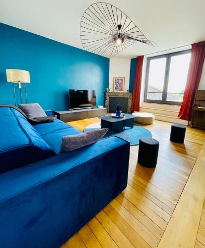 a blue living room with a couch and a tv at Jolie m'Home, Le Puy du Fou, 15 pers, 7 ch, 5 sde, 5 wc in Mauléon