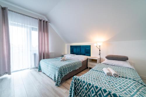 מיטה או מיטות בחדר ב-Pokoje na Żurawiej 10