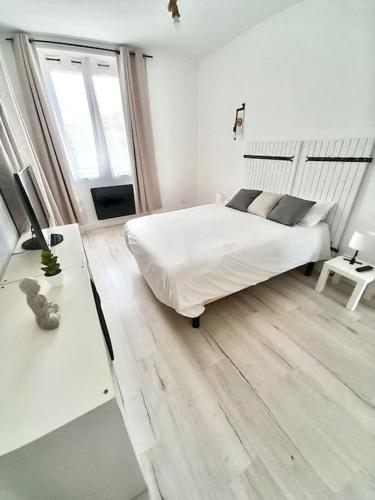 Habitación blanca con cama y escritorio en T3 haut de villa avec terrasse de 25m2, en Toulon