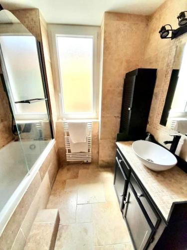 une salle de bain avec un lavabo et une baignoire et un lavabo dans l'établissement T3 haut de villa avec terrasse de 25m2, à Toulon