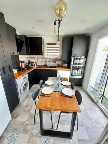 Il comprend une cuisine avec une table et des chaises en bois. dans l'établissement T3 haut de villa avec terrasse de 25m2, à Toulon