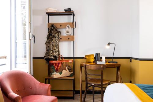 a room with a desk and a table with a chair at Le Village Montmartre by Hiphophostels in Paris