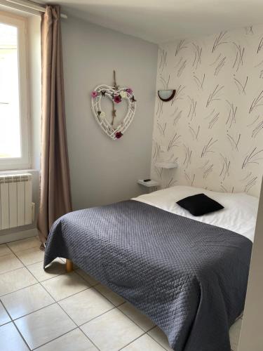 een slaapkamer met een bed en een hartkrans aan de muur bij Café du lac in Manthes