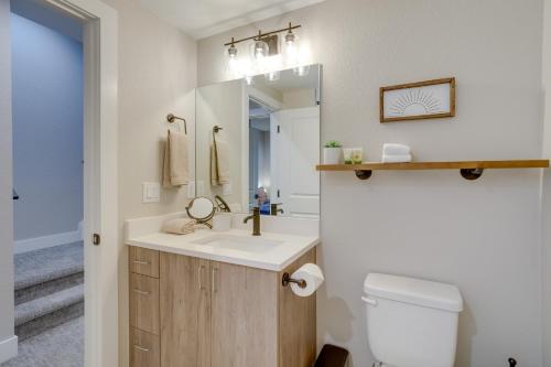 ein Badezimmer mit einem Waschbecken, einem WC und einem Spiegel in der Unterkunft Cozy Denver Vacation Rental Near Broncos Stadium! in Denver