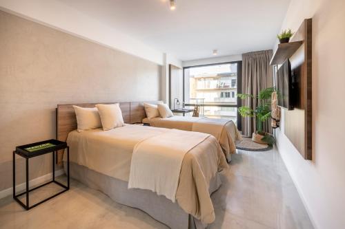 2 Betten in einem Hotelzimmer mit einem TV in der Unterkunft Top Rentals Brickell in Tigre