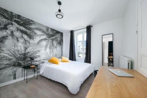 - une chambre avec un lit blanc et un ordinateur portable sur un bureau dans l'établissement Maison entière Dinan centre - 5 chambres, à Dinan