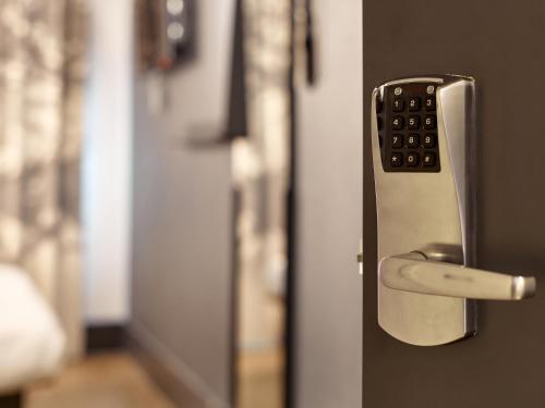 a remote control sticking out of a door at B&B HOTEL Rennes Sud Chantepie in Rennes