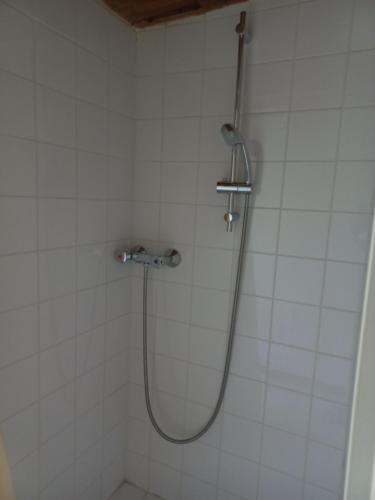 La salle de bains est pourvue d'une douche et de carrelage blanc. dans l'établissement Cabane avec plan d'eau privatif, à Les Hayes