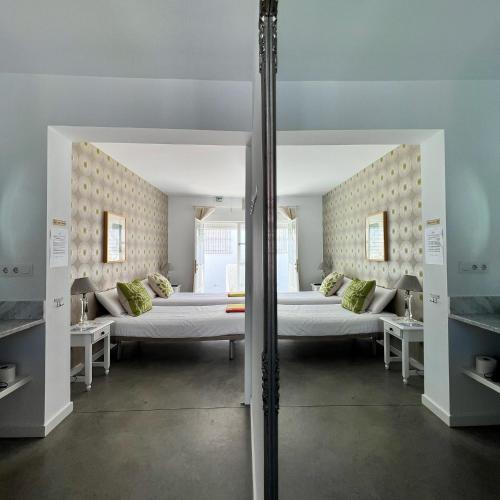 a large room with two beds and two tables at Chipibeach B&B, Hostal Boutique in Chipiona