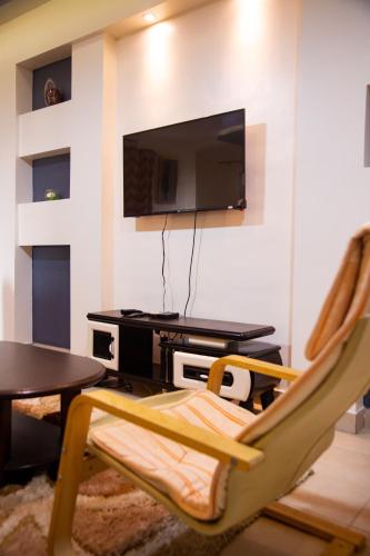 a living room with a tv and a table and chairs at IMOLEASE Kouessi Menontin in Cotonou