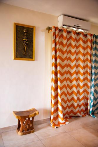 a room with a curtain and a wooden bench at IMOLEASE Kouessi Menontin in Cotonou