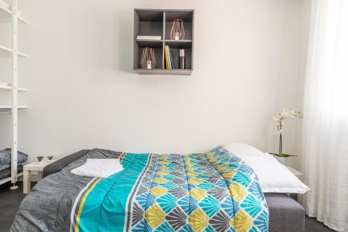 - une chambre avec un lit et une couverture colorée dans l'établissement Studio Ernest Chamalières Calme Parking Gratuit, à Chamalières