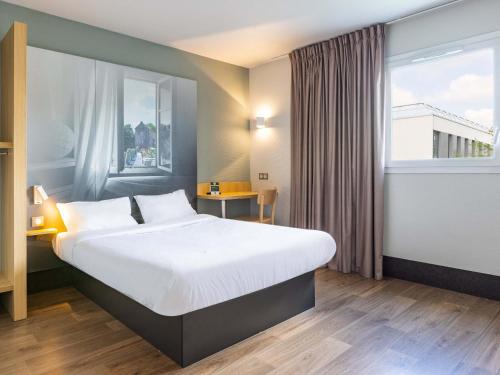 pokój hotelowy z dużym łóżkiem i oknem w obiekcie B&B HOTEL Rennes Ouest Villejean w mieście Rennes