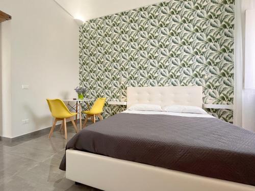 a bedroom with a large bed and yellow chairs at DC House in Procida
