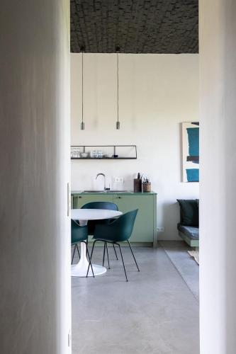 a kitchen with a table and chairs in a room at Groot Noordhof in Nieuwpoort