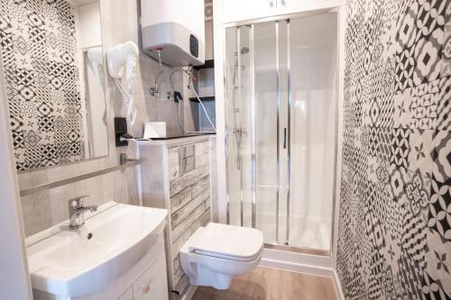 W łazience znajduje się toaleta, umywalka i prysznic. w obiekcie Ustronie Park - beach resort w mieście Ustronie Morskie