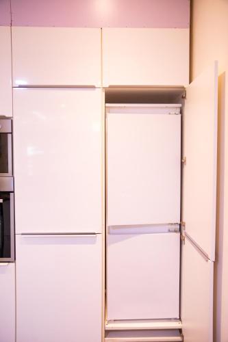 a white closet with glass doors in a room at IMOLEASE Kouessi Menontin in Cotonou