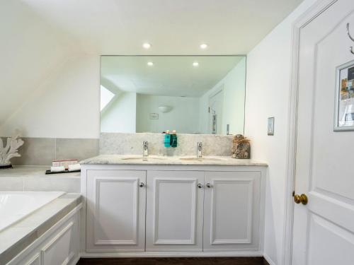 een witte badkamer met een wastafel en een spiegel bij Villiers Hotel in Buckingham