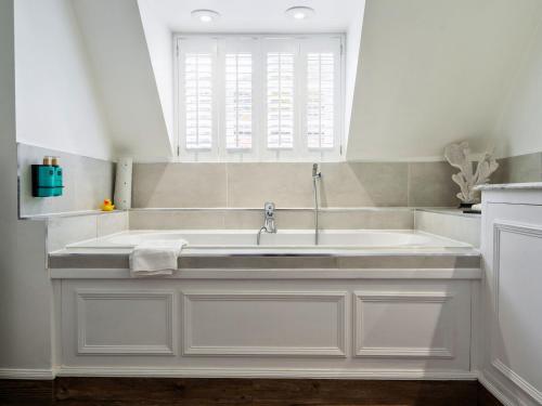 a bathroom with a large sink with a window at Villiers Hotel in Buckingham