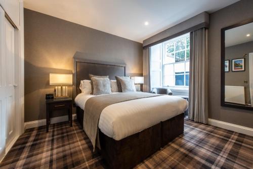 a bedroom with a large bed and a large window at Royal Scots Club in Edinburgh