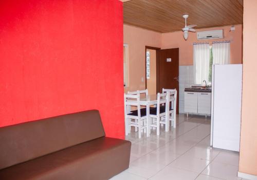 cocina y comedor con pared roja en Residencial Havaí, en Guaratuba