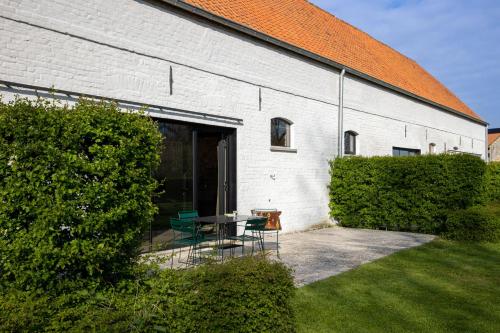 a white building with a table and chairs in a yard at Groot Noordhof in Nieuwpoort