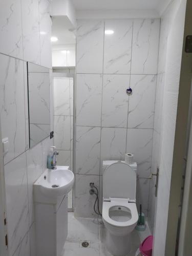 a white bathroom with a toilet and a sink at Artemis Apart&Otel in Bursa