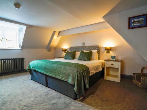 a bedroom with a large bed in a attic at Villiers Hotel in Buckingham