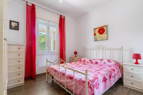 a bedroom with a bed and red curtains at Di Chiara in Torre Lapillo