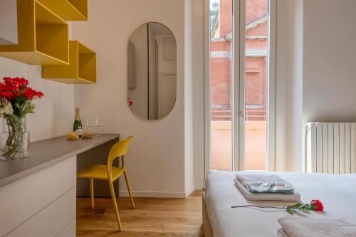 Schlafzimmer mit einem Bett, einem Tisch und einem Spiegel in der Unterkunft BnButler - Sebenico, 28 - Nuovissimo Appartamento in Isola in Mailand