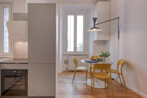 uma cozinha com mesa e cadeiras e uma janela em BnButler - Sebenico, 28 - Nuovissimo Appartamento in Isola em Milão