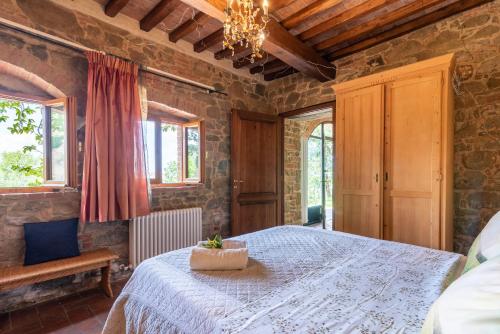 a bedroom with a bed and a chandelier and windows at La Limonaia in Monte San Savino