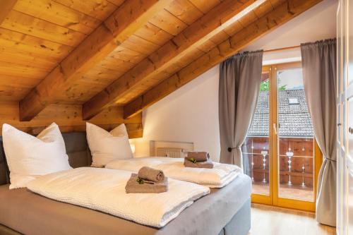 two beds in a room with a large window at Alpblick Apartment Zugspitze in Garmisch-Partenkirchen