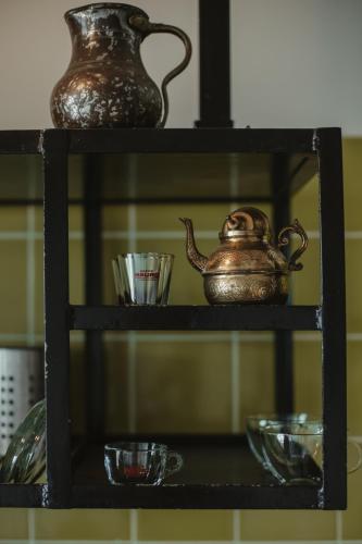 a shelf with tea pots and cups on it at Adika in Ma'ale Gamla