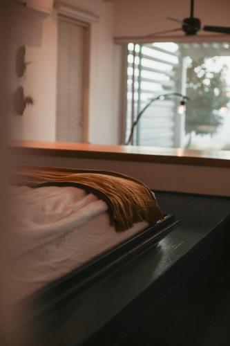 a bed with a brown blanket on top of it at Adika in Ma'ale Gamla