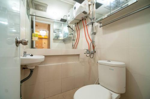 Comfy & stylish 2 Bedrooms At Bassura city في جاكرتا: حمام صغير مع مرحاض ومغسلة
