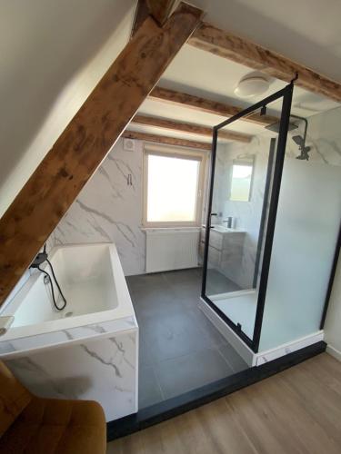 a bathroom with a glass shower and a sink at The island life beach house 1 in De Koog